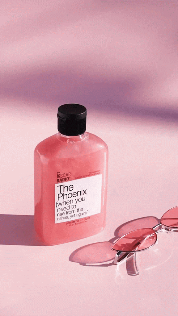 A gif of pink bath wash with bubbles floating by.
